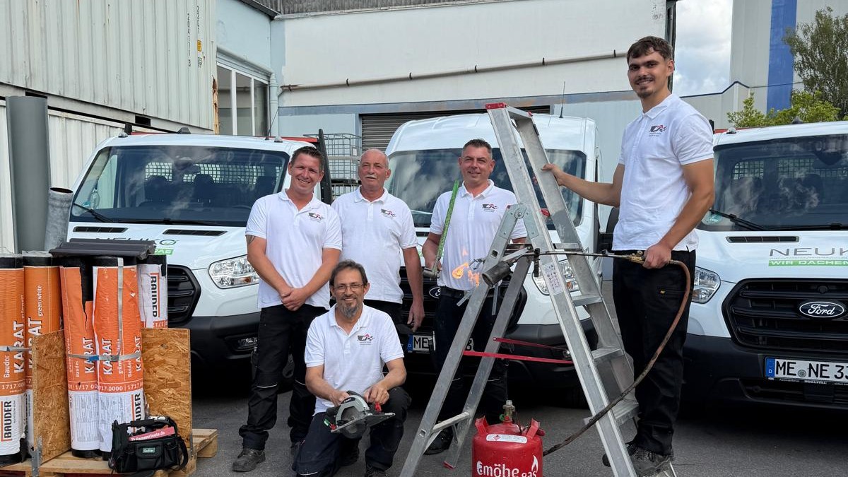 Das NEUKO-Team vor den Firmenfahrzeugen in Monheim am Rhein